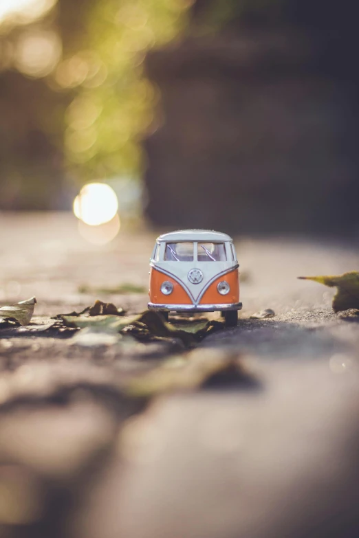 a toy van is sitting on the ground, by Sebastian Spreng, unsplash contest winner, visual art, microbus, soft warm light, bulli, autumnal