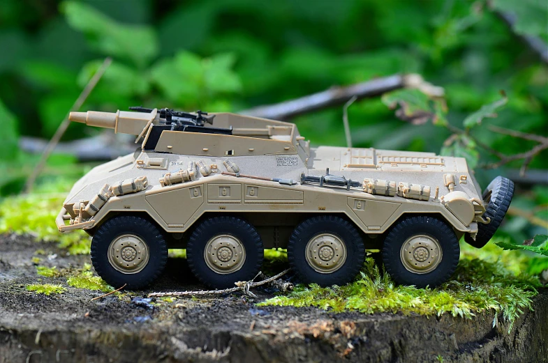 a toy tank sitting on top of a tree stump, fully armoured, tan, slide show, vehicle design