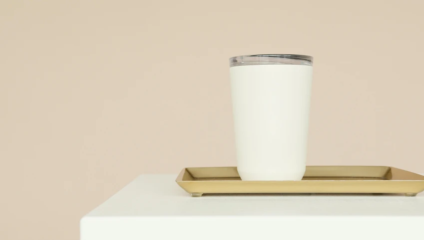 a cup of coffee sitting on top of a tray, a portrait, by Carey Morris, minimalism, white metallic, milkshake, tundra, angled