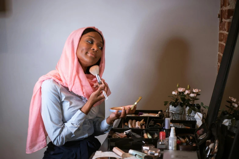 a woman brushing her teeth in front of a mirror, a picture, pexels contest winner, hurufiyya, wearing a head scarf, in professional makeup, pink, ( ( dark skin ) )