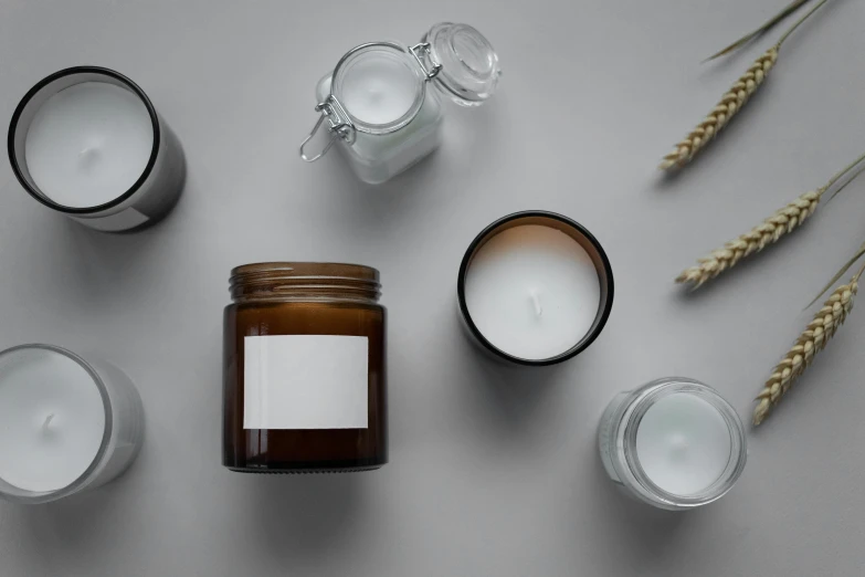 a group of candles sitting on top of a table, on a gray background, lots of jars and boxes of herbs, detailed product image, profile image