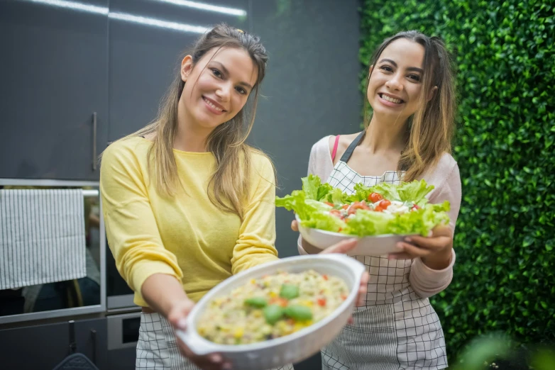 two women standing next to each other holding a bowl of food, pexels contest winner, salad, avatar image, attractive photo, high quality upload