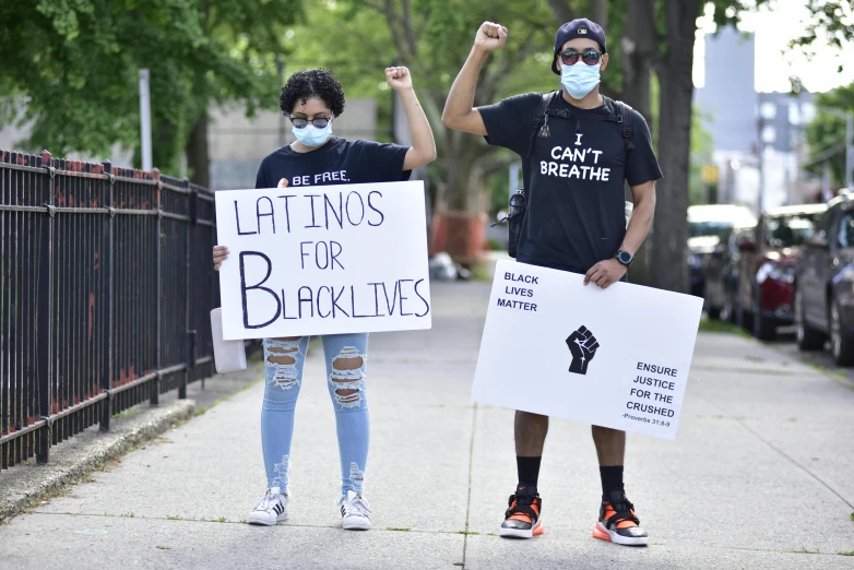 two people standing on a sidewalk holding signs, shutterstock, black arts movement, latino, white bandages on fists, il, thumbnail