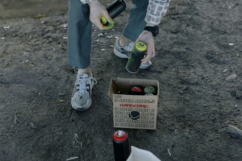 a man is putting a bottle of beer in a box, unsplash, graffiti, tear gas, picking up a can beans, low quality photo, hyperdetailed!