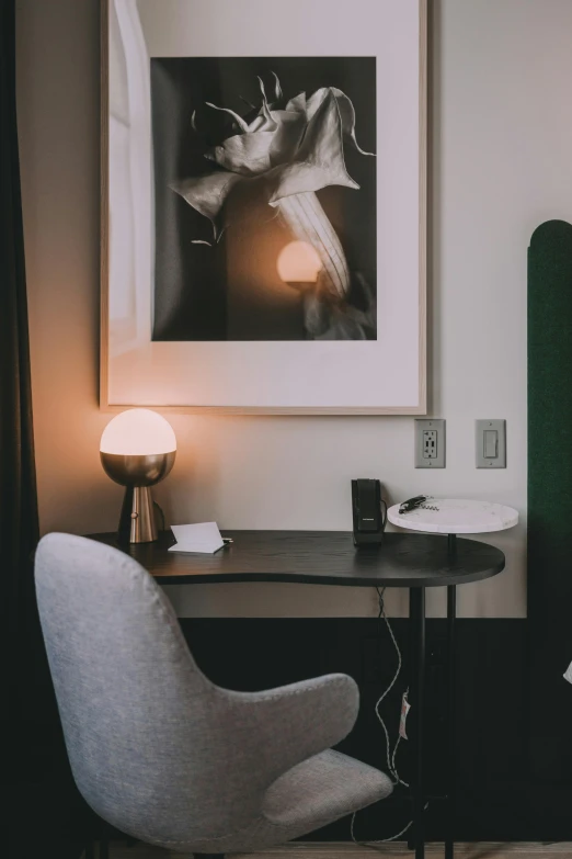 a bed room with a neatly made bed and a chair, by Tom Bonson, trending on unsplash, visual art, table light, charcoal and silver color scheme, emerging from a lamp, hotel room