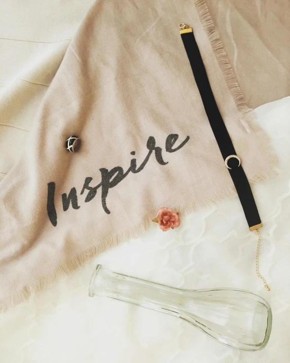 a bag sitting on top of a bed next to a pair of scissors, inspired by Ayshia Taşkın, featured on instagram, inspire and overcome, wearing shoulder cape, flowing lettering, thumbnail