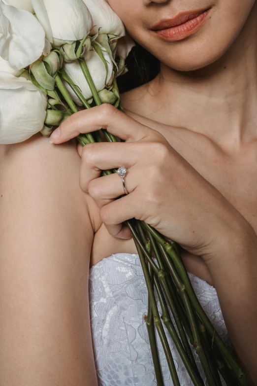 a woman holding a bouquet of white roses, a tattoo, engagement ring ads, subtle detailing, low detail