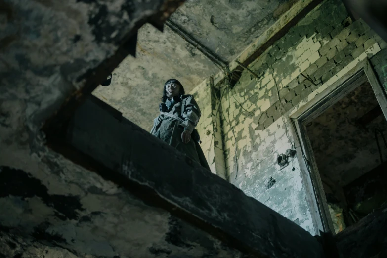 a person sitting on a ledge in a room, an album cover, inspired by Elsa Bleda, pexels contest winner, graffiti, postapocalyptic grunge, costumes from peaky blinders, look down a cellar staircase, action shot girl in parka