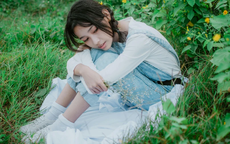 a little girl that is sitting in the grass, an album cover, by Wen Zhenheng, trending on pexels, realism, woman very tired, casual pose, worn out clothes, profile image