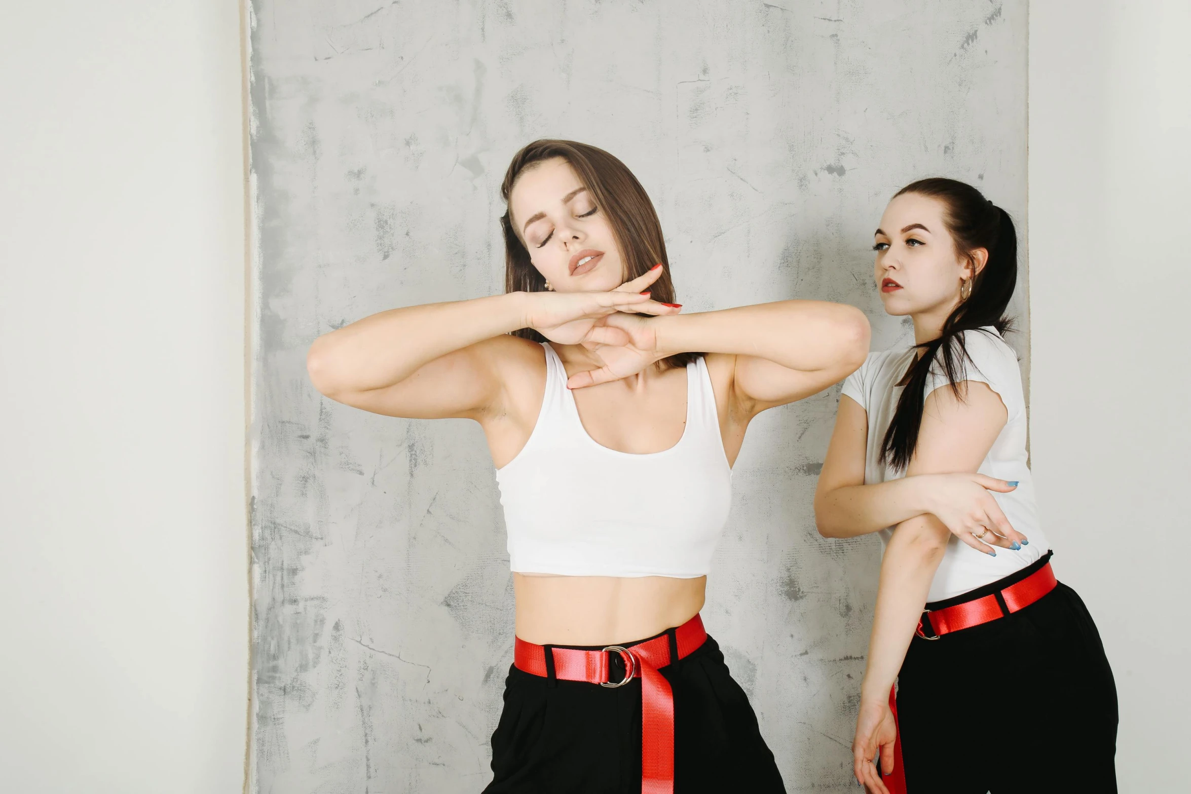 a couple of women standing next to each other, trending on pexels, arabesque, fighting posture, wearing a vest top, bella poarch, karate