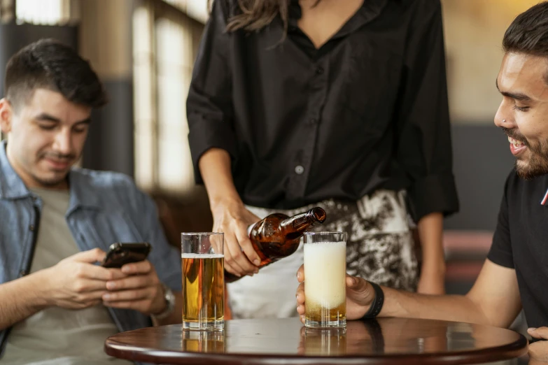 a group of people sitting around a table with drinks, easy to use, pouring, uploaded, brown