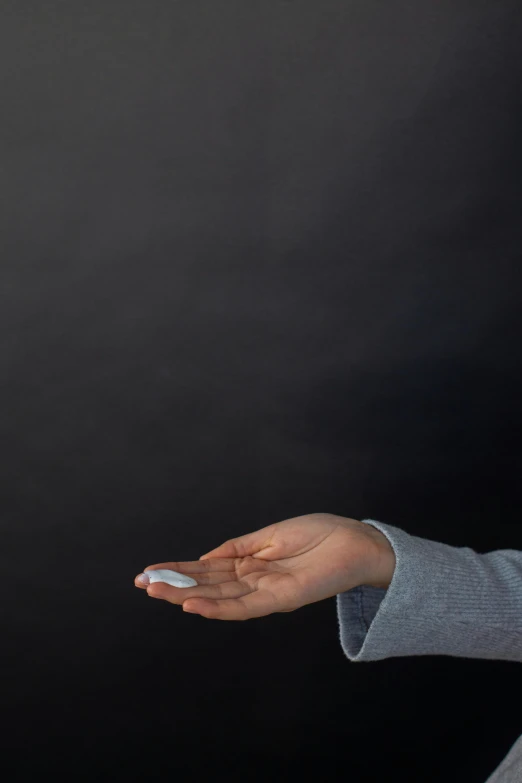 a woman holding a remote control in her hand, by artist, unsplash, conceptual art, offering the viewer a pill, in front of a black background, hegre, soft opalescent membranes