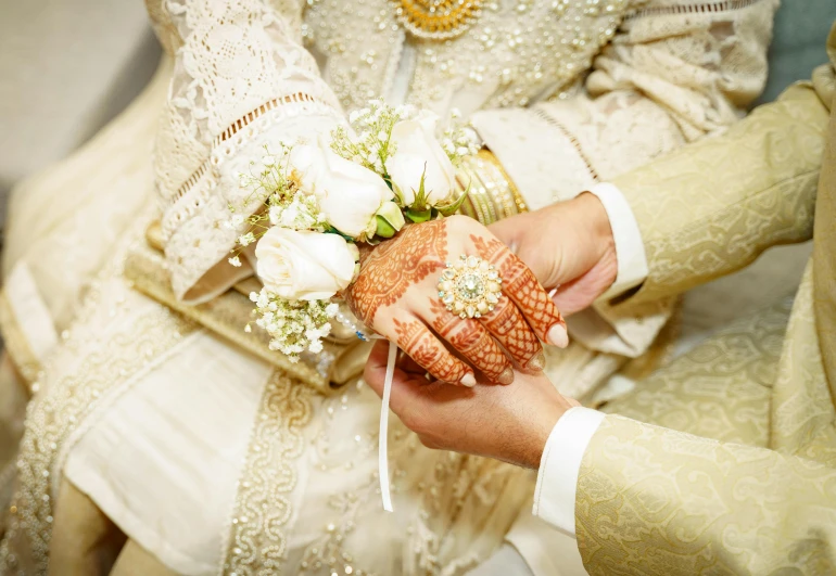 a close up of a person holding a bouquet of flowers, gold and white robes, malaysian, holding hands, multiple stories