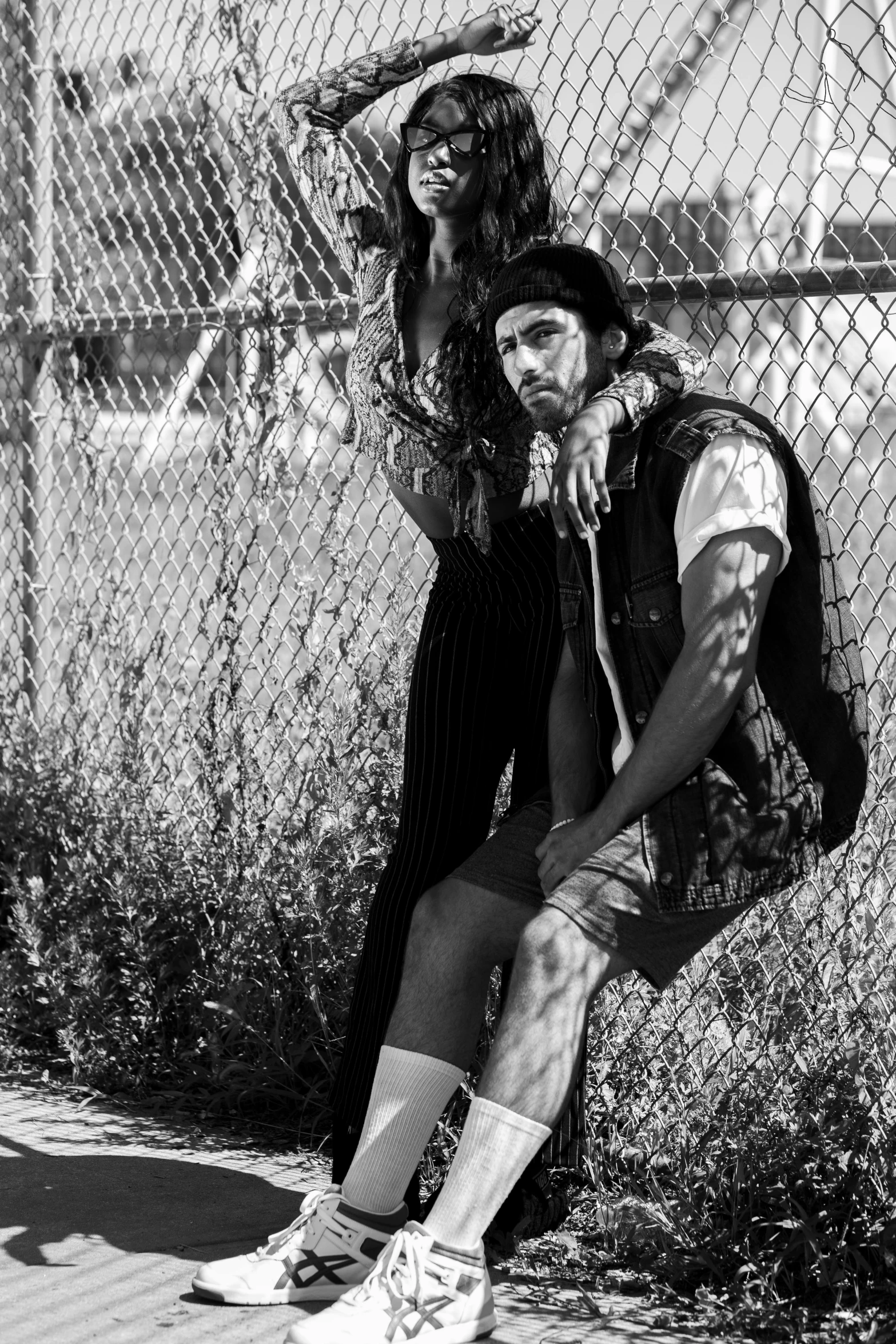 a man sitting on top of a skateboard next to a woman, a black and white photo, by Alexis Grimou, renaissance, avan jogia angel, lumberjack, post malone, fashion magazine editorial