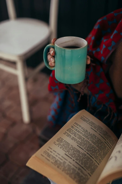 a person holding a cup of coffee and an open book, a portrait, pexels contest winner, teal, square, cottagecore hippie, ( 3 1