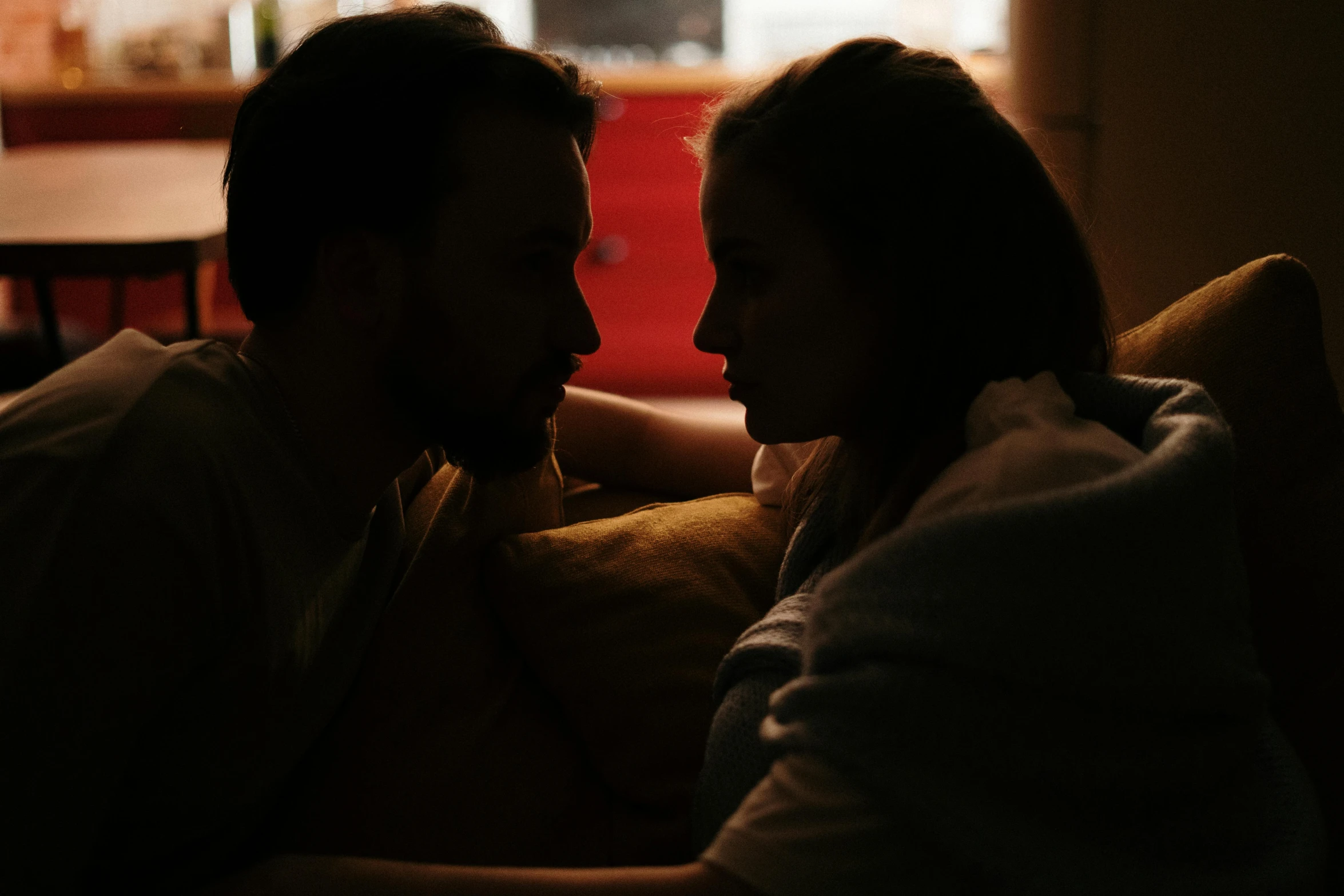 a man and a woman sitting on a couch, pexels contest winner, romanticism, soft light from the side, ( ( theatrical ) ), face to face, dimly lit bedroom