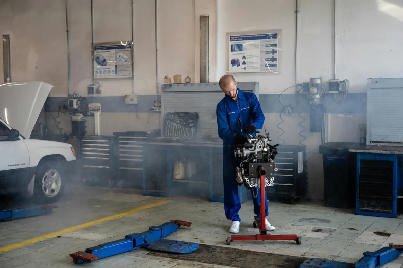 a man working on a car in a garage, by Andries Stock, blue, crying engine, avatar image, maintenance photo