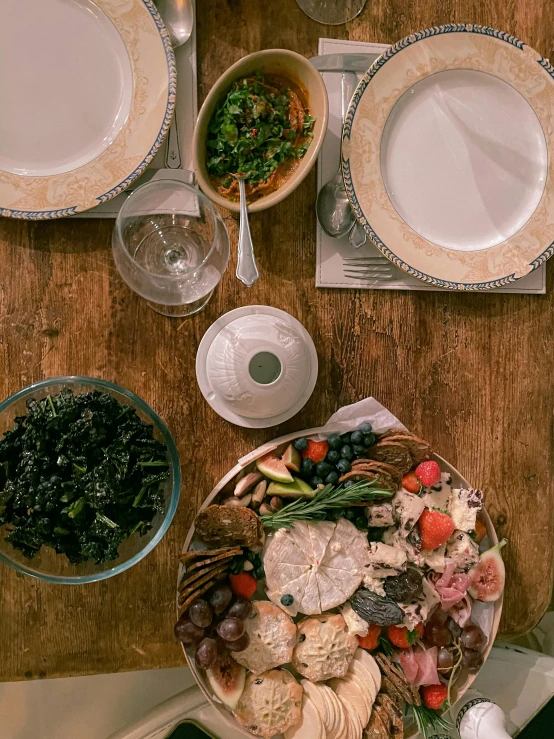 a wooden table topped with plates of food, by Carey Morris, unsplash, renaissance, low quality photo, salad, family photo, taken on iphone 14 pro