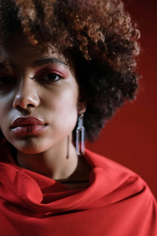 a close up of a person wearing a red shirt, by Lily Delissa Joseph, trending on pexels, afrofuturism, curls, ashteroth, portrait sophie mudd, promotional image