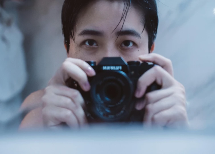 a man taking a picture of himself with a camera, pexels contest winner, photorealism, asian male, sharp focus on eyes, in front of a computer, looking in the mirror