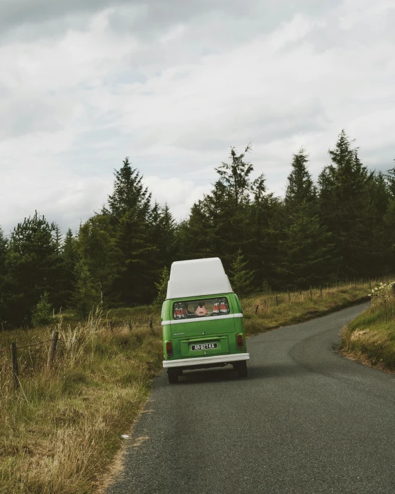 a green van driving down a country road, by Jessie Algie, retro photography, highlands, high quality image, ignant