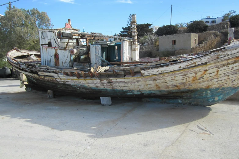 a boat sitting on top of a cement parking lot, by Terese Nielsen, hurufiyya, yellowed with age, restoration, george patsouras, slightly muscular