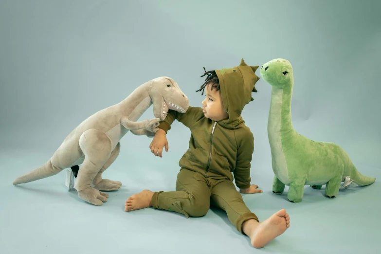 a baby sitting on the floor surrounded by stuffed animals, inspired by Abidin Dino, trending on pexels, fantastic realism, wearing a tracksuit, avatar image, green and brown clothes, brachiosaurus