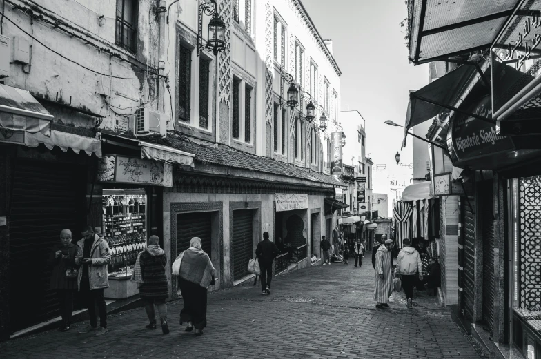 a black and white photo of people walking down a street, les nabis, moroccan city, people shopping, clean streets, taken in 2 0 2 0