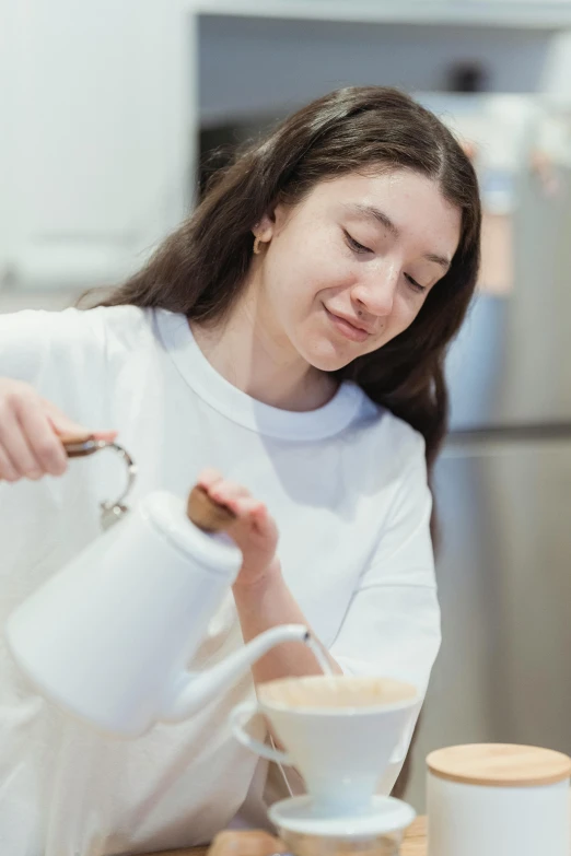 a woman is pouring a cup of coffee, by Nicolette Macnamara, teen girl, soymilk, profile image, cooking