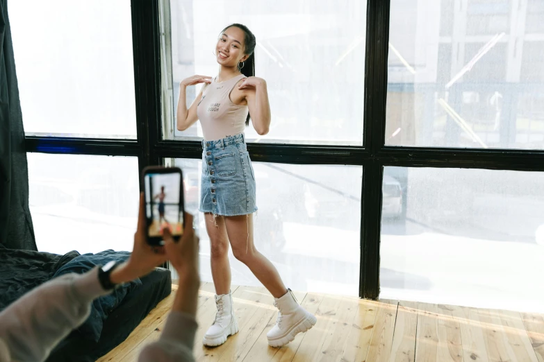 a woman standing in front of a window taking a picture of herself, happening, wearing crop top and miniskirt, joy ang, wearing skirt and high socks, multiple poses