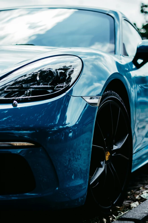 a blue sports car parked on the side of the road, inspired by Harry Haenigsen, pexels contest winner, photorealism, extreme close up shot, porsche, thumbnail, pearlescent