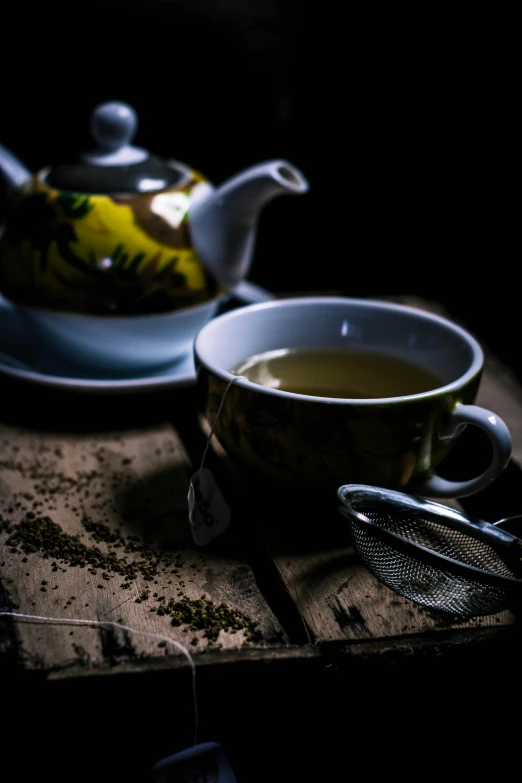 a tea pot sitting on top of a wooden table, with a black background, square, thumbnail, green tea