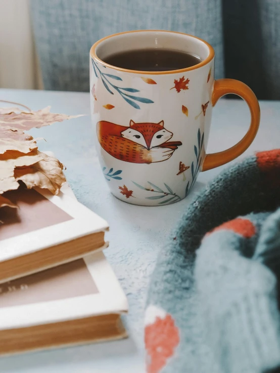 a stack of books sitting on top of a table next to a cup of coffee, a cross stitch, trending on pexels, cute fox, seasons!! : 🌸 ☀ 🍂 ❄, profile image, profile picture