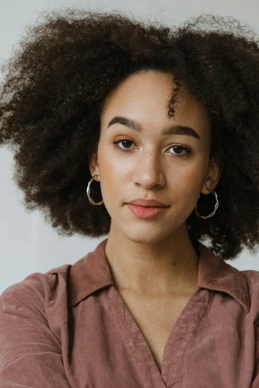 a close up of a person with an afro, a character portrait, trending on pexels, portrait sophie mudd, hoop earrings, half - length head portrait, light-brown skin