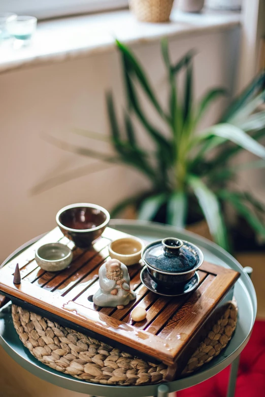 a table that has some cups on it, a still life, inspired by Cui Bai, trending on unsplash, health spa and meditation center, high angle close up shot, shrines, pot