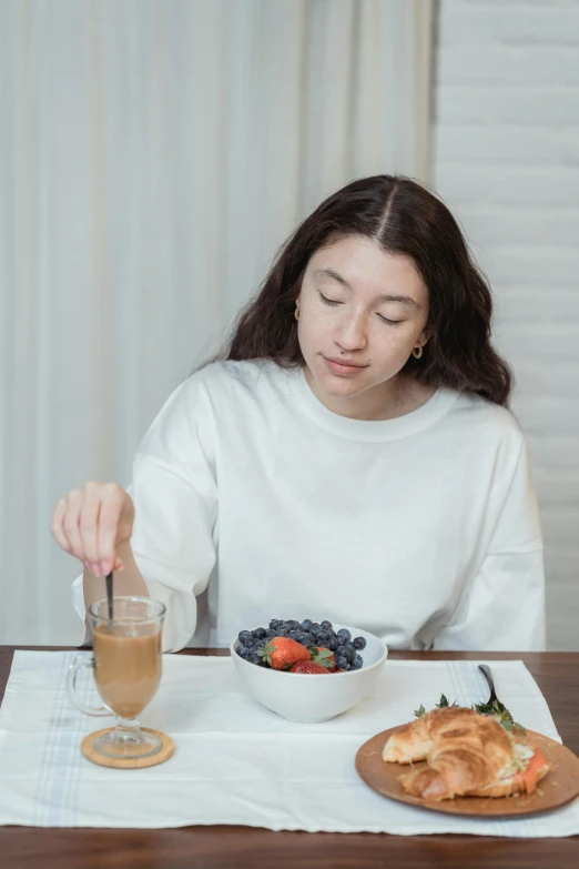 a woman sitting at a table with a plate of food, trending on pexels, realism, berries dripping juice, soymilk, gif, slightly minimal