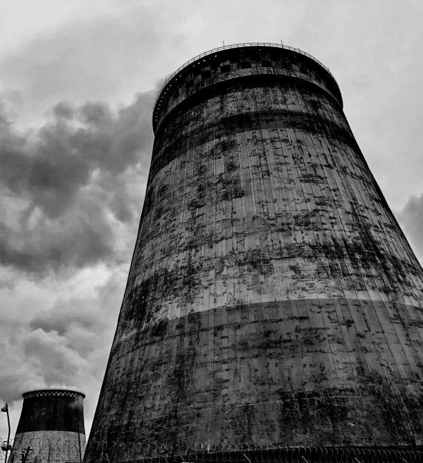 a black and white photo of two cooling towers, a portrait, by Edward Bailey, pexels contest winner, toxic clouds, grungy, fine art print, low angle photograph