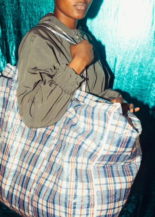 a close up of a person holding a bag, by Matija Jama, happening, tartan garment, sza, 90's color photo, cotton