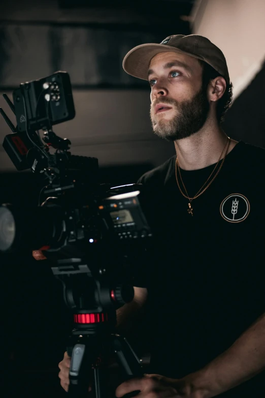 a man standing in front of a camera, production ig, he is wearing a black t-shirt, **cinematic, ( ( theatrical ) )