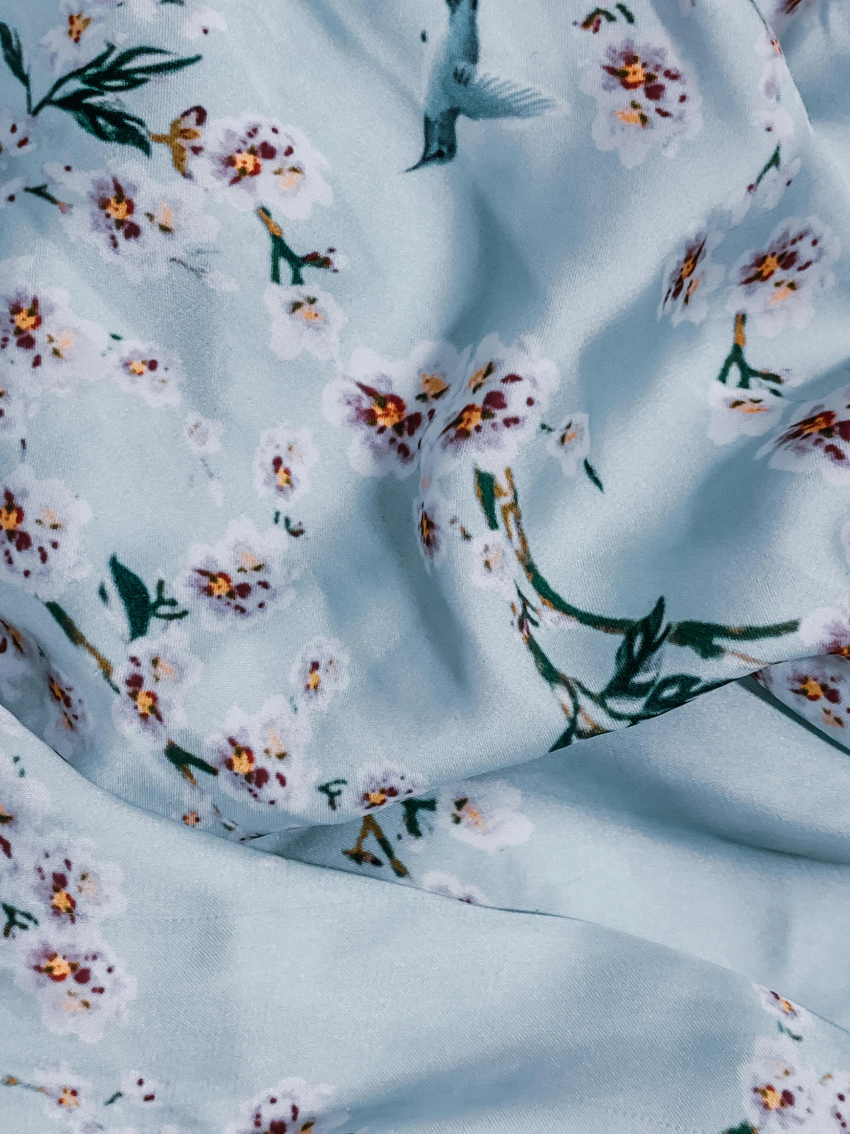 a close up of a sheet with flowers on it, soft silk dress, pale blue, without duplicate image