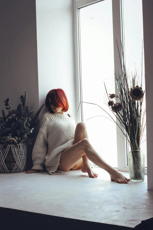 a woman sitting on a window sill next to a vase of flowers, unsplash contest winner, aestheticism, red hair girl, wearing an oversized sweater, bare thighs, anna nikonova aka newmilky