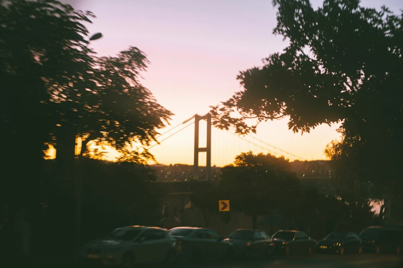 cars parked on the side of the road with a bridge in the background, inspired by Elsa Bleda, pexels contest winner, hurufiyya, istanbul, summer sunset, an archway, 90's photo