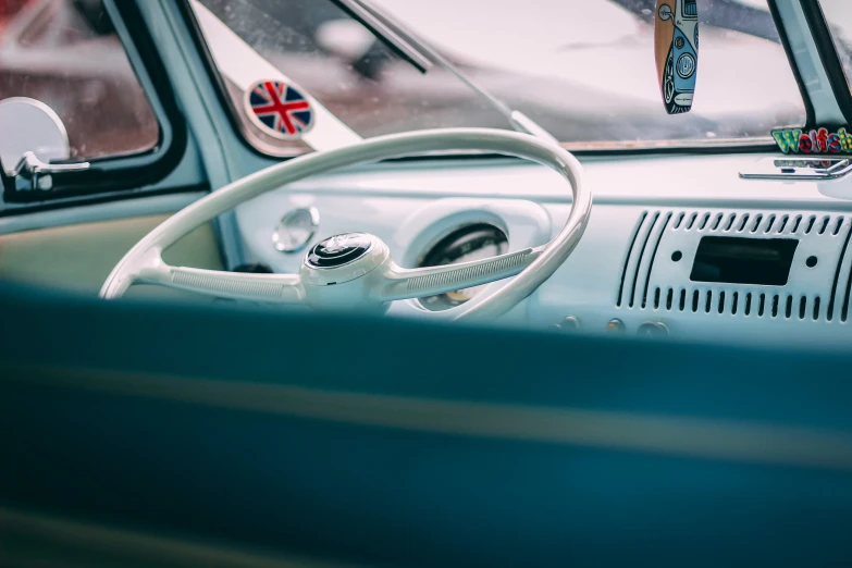 a close up of a steering wheel in a car, by Tom Bonson, unsplash, retrofuturism, kombi, white and blue, casually dressed, pastel'