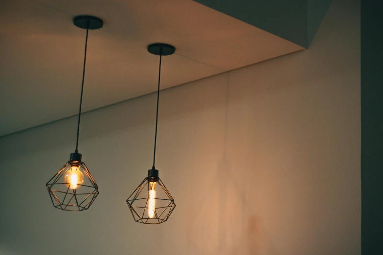 a couple of light bulbs hanging from a ceiling, pexels contest winner, light and space, angular minimalism, lantern light besides, thin wires, architectural finishes