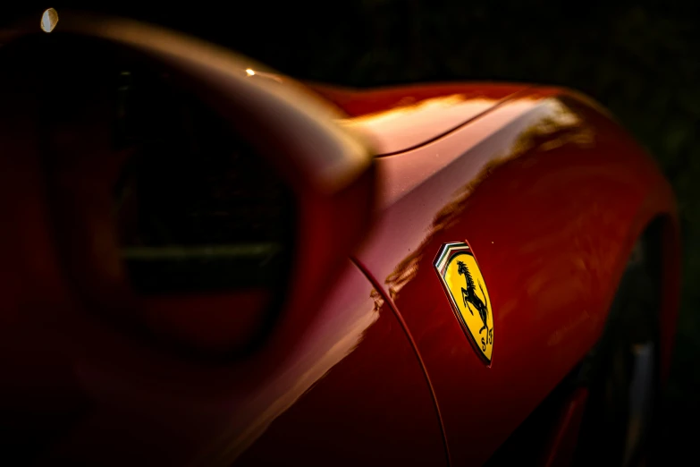 a ferrari logo on the side of a red car, a photo, pexels contest winner, renaissance, taken at golden hour, icon, in rich color, back