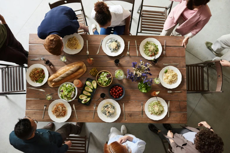 a group of people sitting at a table with plates of food, by Carey Morris, pexels contest winner, renaissance, sustainable materials, white table, a wooden, tall