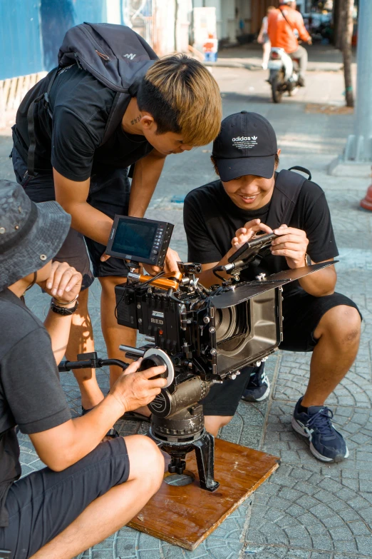 a group of men standing around a camera, production ig, mid action, maintenance, fully in frame