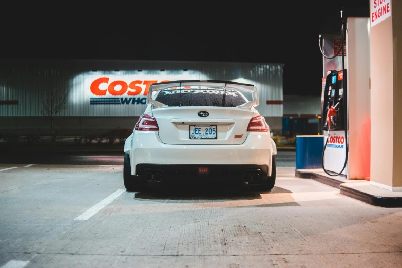 a white car is parked at a gas station, by Matt Cavotta, pexels contest winner, ((in a super market costco)), japanese drift car, rear lighting, ad image