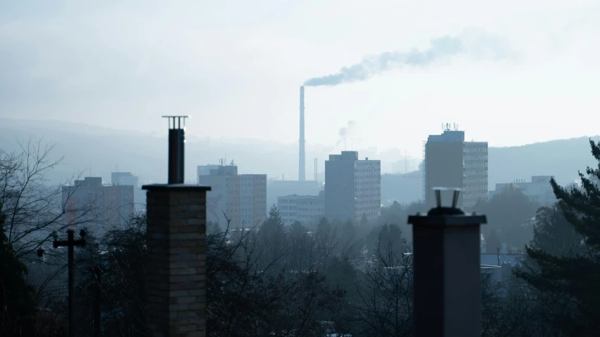 a view of a city from the top of a hill, inspired by Elsa Bleda, pexels contest winner, bauhaus, chimney with smoke, swedish urban landscape, industrial pipes, slight haze