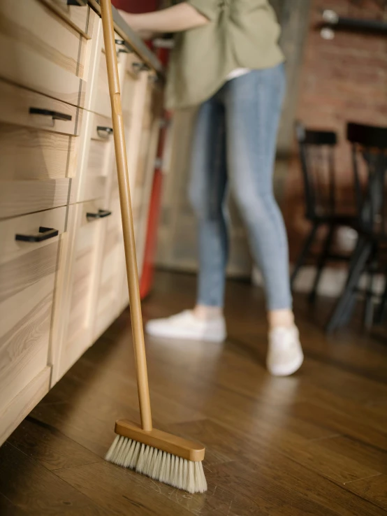 a woman sweeping the floor with a broom, pexels contest winner, wooden cabinet, high resolution product photo, upscaled to high resolution, miniature product photo